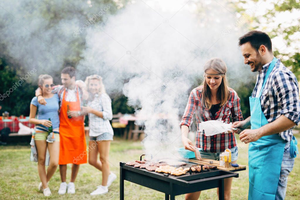 Happy friends enjoying barbecue party outdoors