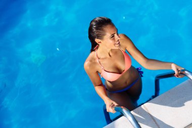 Güzel esmer yüzme ve havuz rahatlatıcı