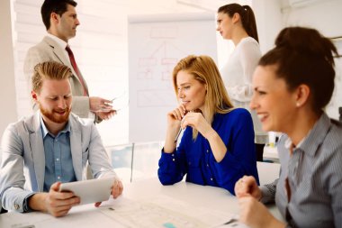 İş adamları ofiste yeni fikirler üzerinden işbirliği yapıyor ve konuşuyorlar.