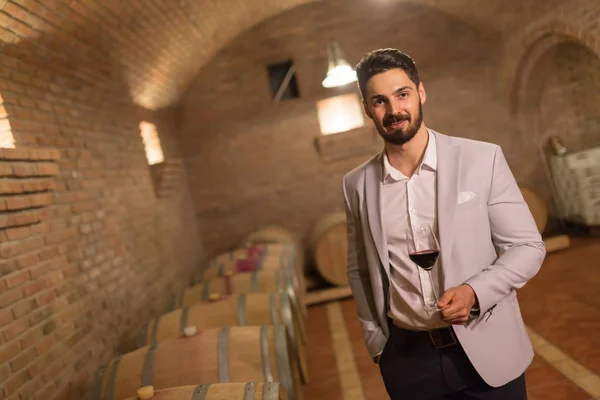 Wine maker testing wines in winery basement