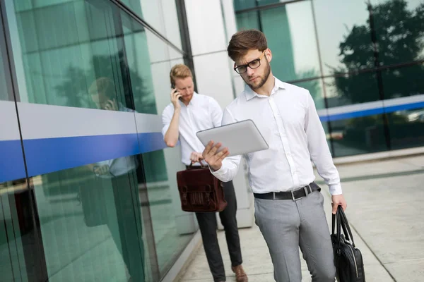 Açık havada yürüyüş ve kullanarak iş adamları telefonları Tablet