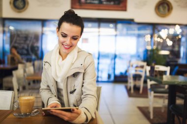 Kafede dijital tablet kullanarak çekici genç kadın