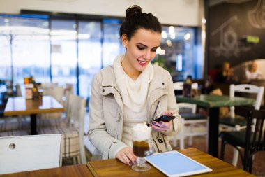 Kafede dijital tablet kullanarak çekici genç kadın