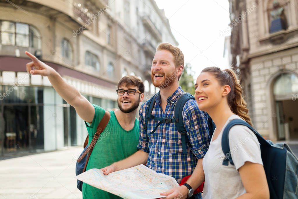 Young happy tourists holding map sightseeing in city