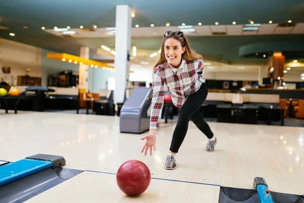 Beautiful young and happy woman enjoying bowling