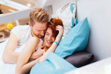 Güzel çift yatakta gülümseyen ve yapıştırma