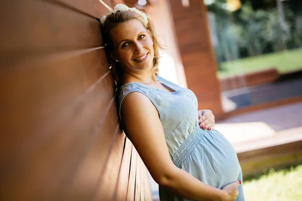 彼女の腹を保持している美しいブロンドの妊娠中の女性 — ストック写真