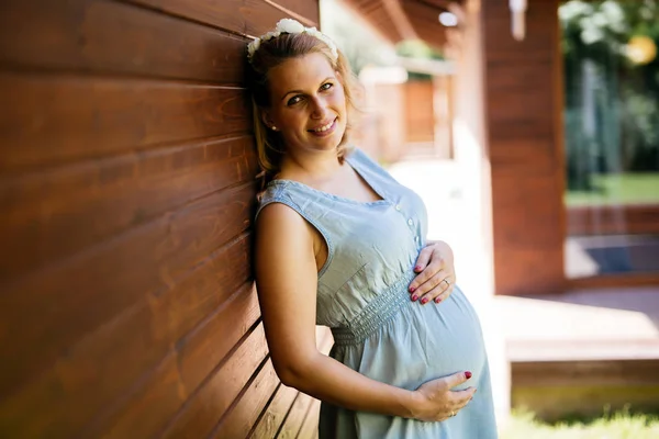 彼女の腹を保持している美しいブロンドの妊娠中の女性 — ストック写真