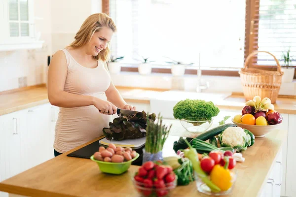 Hermosa mujer embarazada preparando comida —  Fotos de Stock