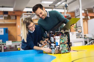 Mekatronik projede birlikte çalışan genç çekici öğrenci