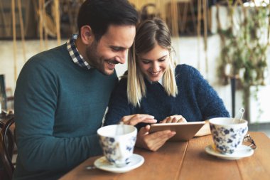 Genç çekici çift dijital tablet kahve dükkanında kullanma