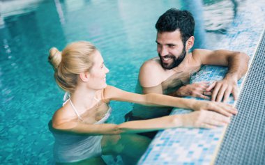 Mutlu çekici çift rahatlatıcı spa yüzme havuzunda
