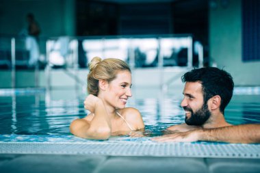 Mutlu çekici çift rahatlatıcı spa yüzme havuzunda