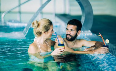 Mutlu çekici çift rahatlatıcı spa yüzme havuzunda