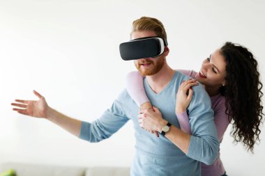 Sanal gerçeklik kulaklık evde çalışırken çekici genç Çift