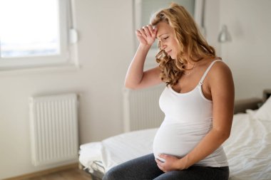Baş ağrısı acı hamile sarışın kadın portresi