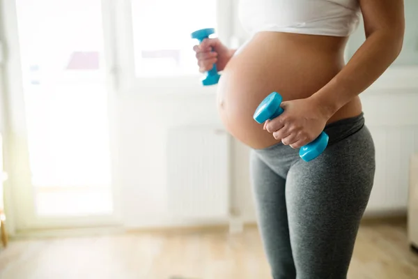 スポーティなフィットネス妊娠中の女性 自宅で演習を行う — ストック写真
