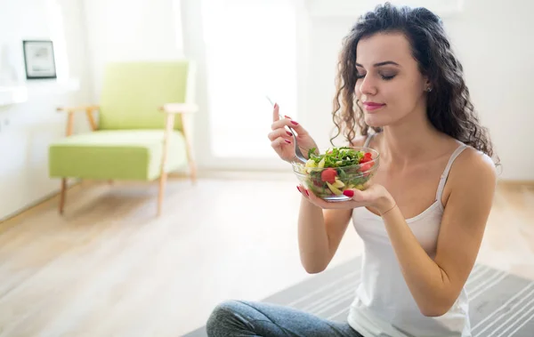 Fitness young woman eating healthy food after workout