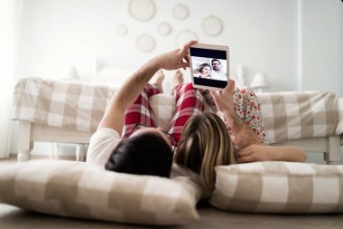 Genç çekici çift yatak odasında dijital tablet kullanma