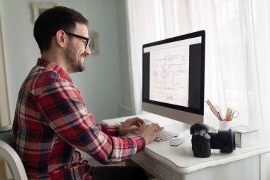 Evde kendi bilgisayarında proje üzerinde genç yakışıklı Tasarımcısı