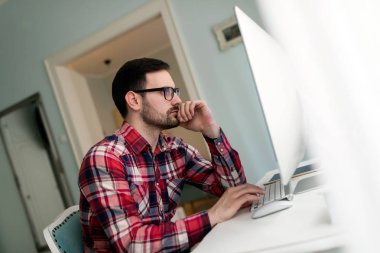 Evde kendi bilgisayarında proje üzerinde genç yakışıklı Tasarımcısı