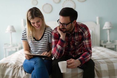 Genç çekici çift yatak odasında dijital tablet kullanma