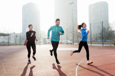 Mutlu arkadaşlar spor yaparken dışarıda aktif ve sağlıklı bir yaşam sürerler.