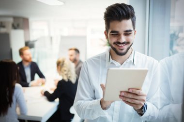 Mutlu işadamı tablet kullanarak modern ofis takım elbise giymiş