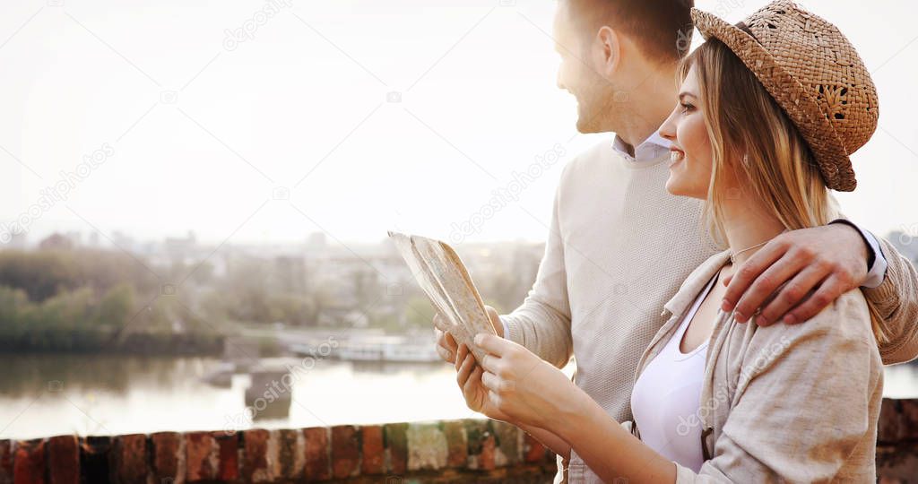 Happy tourist couple in love with map traveling outdoors