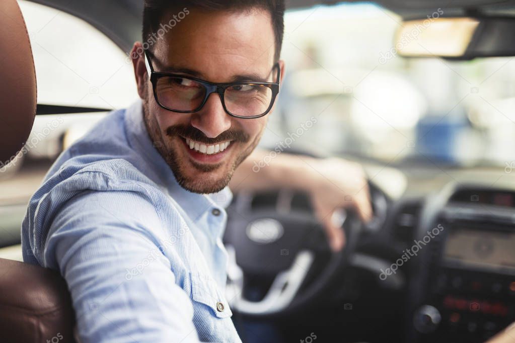 Handsome smart businessman driving a car to work