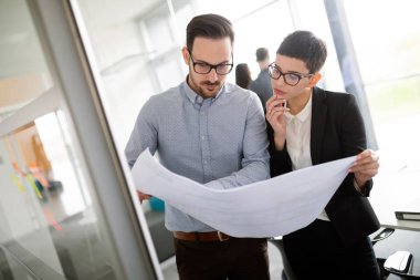 Bir grup mimar ve iş adamı birlikte çalışıyor ve beyin fırtınası yapıyorlar.