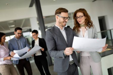 Bir grup mimar ve iş adamı birlikte çalışıyor ve beyin fırtınası yapıyorlar.