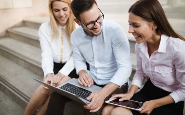 İş arkadaşları laptop bakarken gülüyor