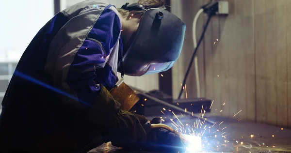 Metal worker welding with torch in metal industry factory