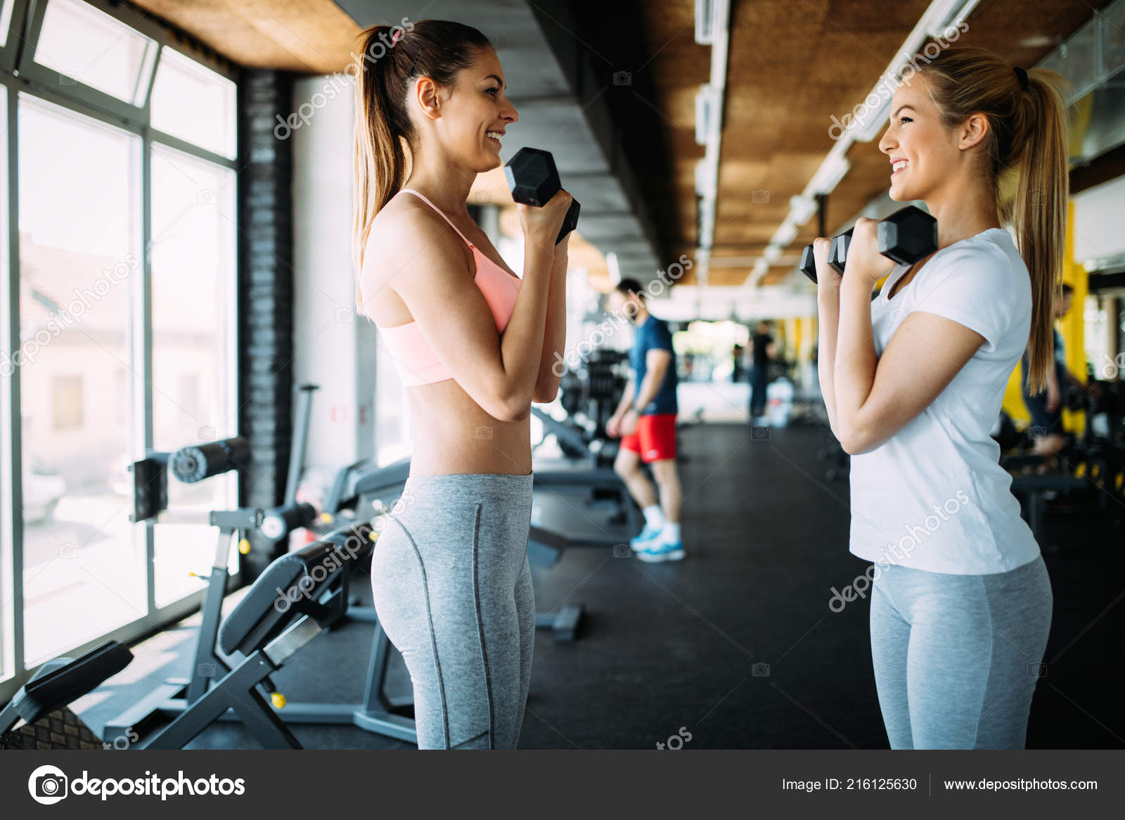 two fit girls training with personal trainer in gym, attractive