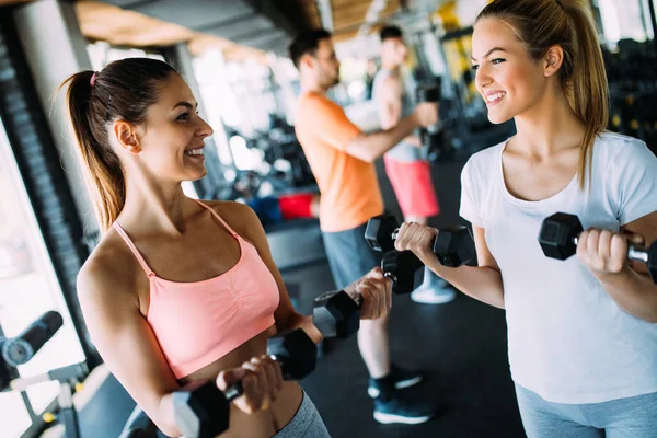 Women working out in gym strengthening their physique