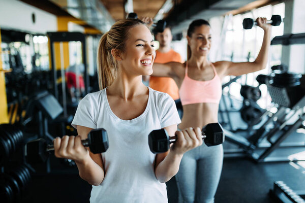 Women working out in gym strengthening their physique