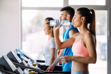 spor salonunda egzersiz sırasında genç kadın içme suyu