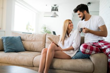 Mutlu çift aşık evde pijamayla tablet kullanma