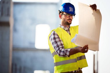 Genç iş adamı inşaat sitesi mühendis mavi baskı ile