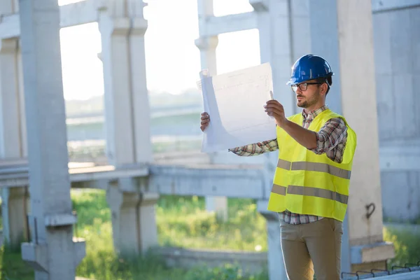 Picture of construction site engineer looking at construction plan