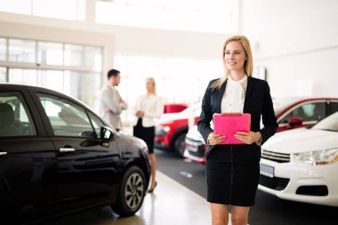 Araç showroom içinde duran güzel genç pazarlamacı portresi