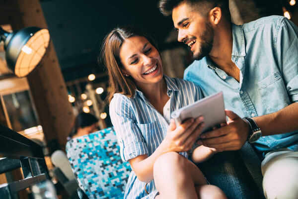 Young attractive cheerful couple on date in coffee shop