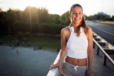 Gün batımında köprüde koşan güzel kadın