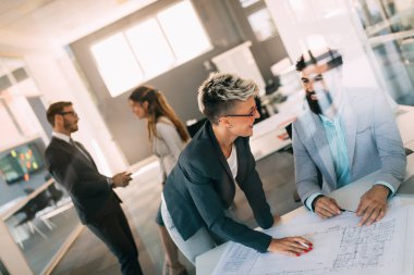 Bir grup mimar ve iş adamı birlikte çalışıyor ve beyin fırtınası yapıyorlar.