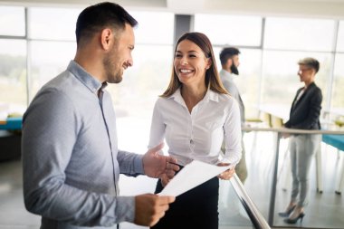 İş adamı önerilerini meslektaşlarına sunuyor. Girişim ekibi modern parlak ofiste toplanıyor.