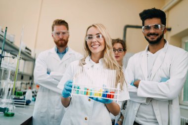 Grup genç başarılı bilim adamı laboratuvar kamera için poz