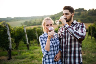 Mutlu şarap yetiştiricileri şarap tadıyor üzüm bağında