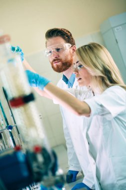 Laboratuvarda birlikte çalışan genç kimya öğrencileri.