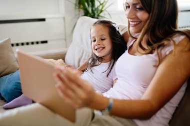 Dijital tablet kullanarak sevimli kızıyla birlikte mutlu anne